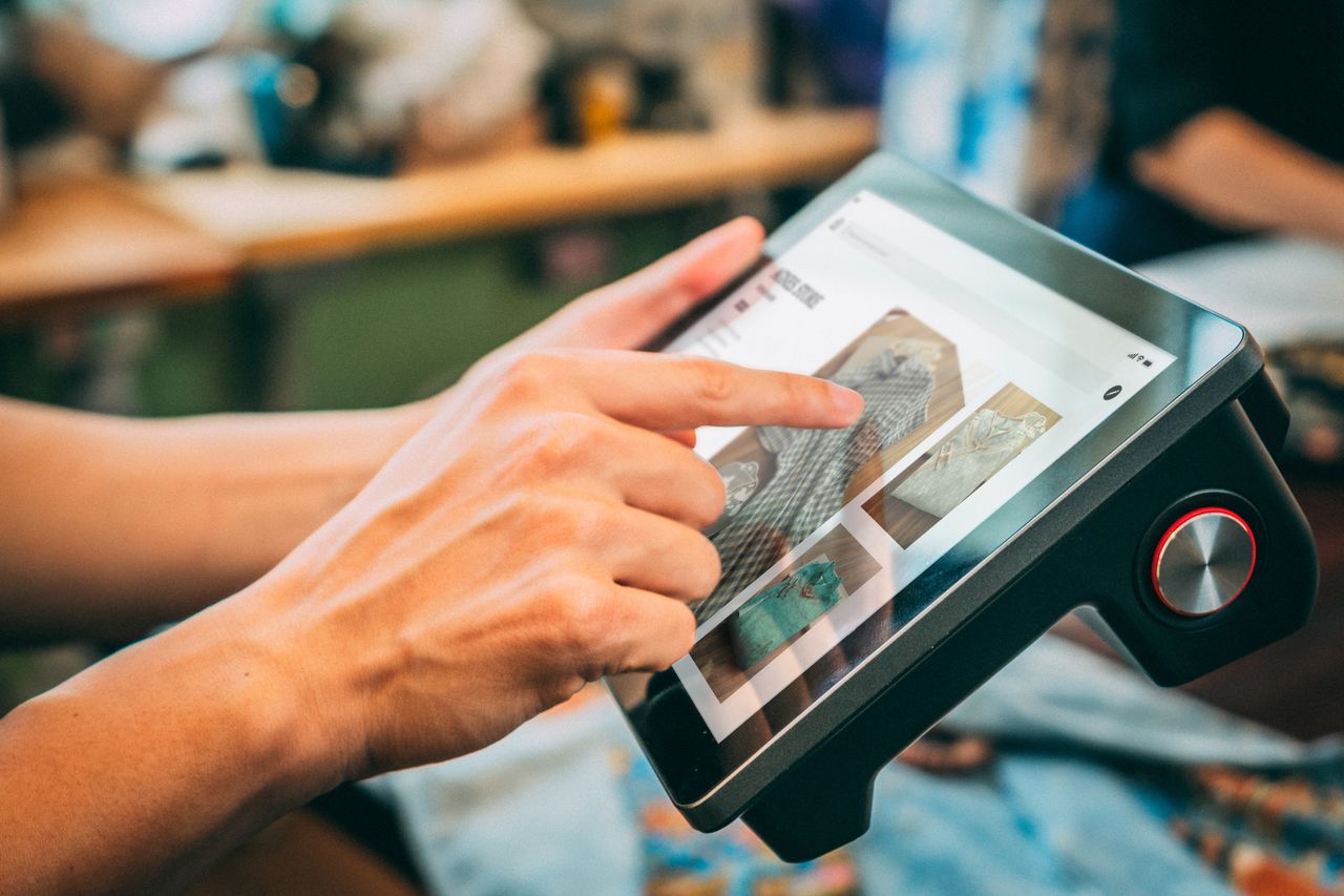 Vue rapprochée de mains interagissant avec un écran tactile, mettant en avant du contenu numérique.